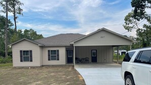 A single-story house with a covered porch, a garage, and a driveway. - New 3-bedroom house in beautiful Douglas with cool AC and warm heat (Douglas)