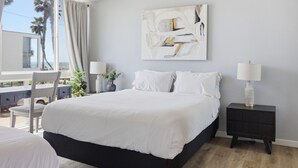 A bedroom with a large bed, a nightstand, a lamp, a painting, and a view of the outside. - Ocean View Oasis in Pacific Beach 2BR 2BA Balcony Pool  Monthly Stay (San Diego)