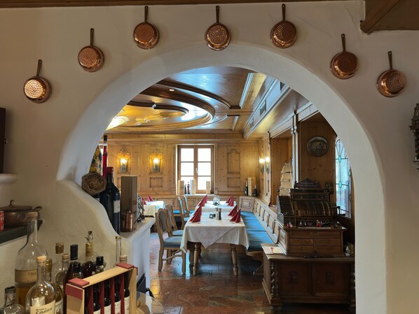 Un restaurant à l’intérieur en bois, une table dressée et un présentoir à bouteilles.