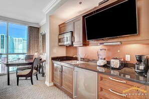 A modern kitchen with a large window, stainless steel appliances, and a flat-screen TV. - MGM Signature (Las Vegas)