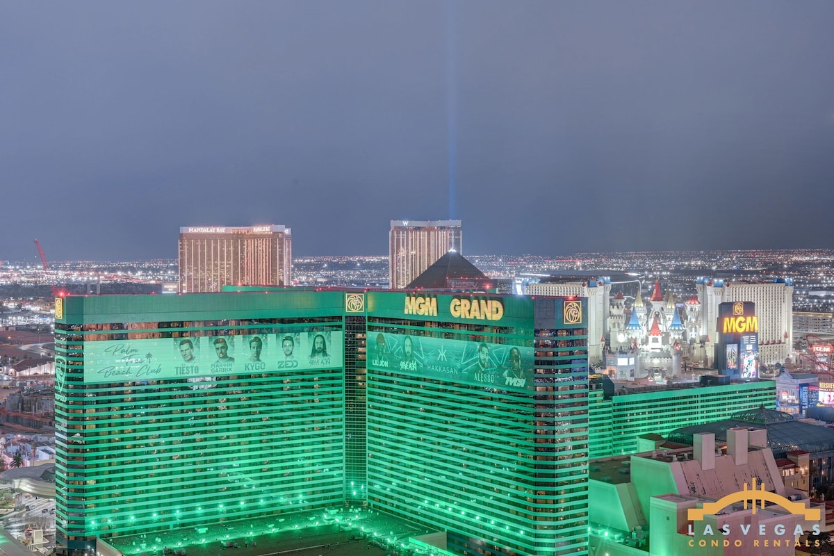 Un edificio grande de varios pisos con el letrero del MGM Grand, que presenta un casino y señalización de hotel destacados, y una vista del horizonte de Las Vegas al fondo.