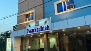 Een meerlaags gebouw met een bord met de tekst 'Dwarkadhish' bij de ingang.