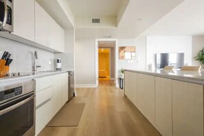 Eine moderne Küche mit weißen Schränken, Edelstahlgeräten und Holzboden.