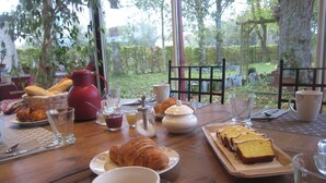 A breakfast table with croissants, bread, and a teapot. - Guest Room "Les Charmilles - Beige Room" (Charny-sur-Meuse)