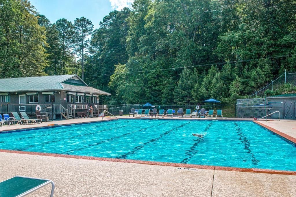 A swimming pool with lounge chairs and a building in the background.
