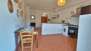 Una cocina compacta con comedor, lavadora y horno integrado.