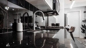 A modern kitchen with a large sink, stainless steel appliances, and a marble countertop. - Luxury Comfort Stay in Keswick | 2Bedrooms- 1Bath (Edmonton)