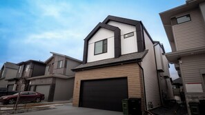 A modern residential building with a garage, a visible number, and a clear sky. - Luxury Comfort Stay in Keswick | 2Bedrooms- 1Bath (Edmonton)