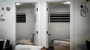 A bedroom with a bed, a chair, and a wardrobe with a mirror. - Luxury Comfort Stay in Keswick | 2Bedrooms- 1Bath (Edmonton)