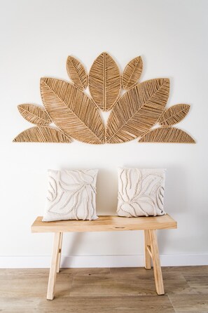 A wooden bench with two cushions against a wall with a woven leaf pattern. - C Gato 7 Riscas - Casa Maior (Obidos)