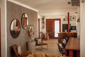 A modern dining area with a wooden table, chairs, and a large mirror on the wall.