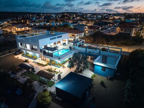 A modern two-story house with a swimming pool, multiple balconies, and a covered outdoor seating area. - The View,  a grandiose luxury, spacious private villa with pool and ocean view! (Grote Berg)