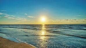 A beach with sunlight reflecting on the water. - Sunkissed Seaside by Avantstay Walk to Beach + Boardwalk Pool + Tennis + Basketball Access (Port Aransas)