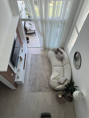 Un salon moderne avec un canapé, une télévision et des objets de décoration.