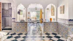 A hotel lobby with a checkered floor, a dining area with a round table, and patterned walls. - Lovely 2-El Jadida City Center Apt – Ideal Spot, Beach View & WiFi (El Jadida)