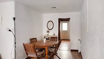 A dining room with a wooden table and chairs, a lamp, and a mirror on the wall.
