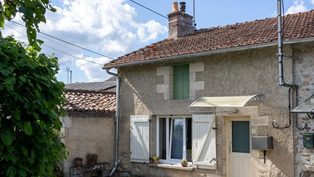 A rustic stone building with a tiled roof, a small porch, and a door with a green shutter. - Gîte La Traverse: Private Terrace, Private Garden, and Wi-Fi in Persac (Persac)