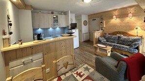 A compact living space with a kitchenette, a sofa, a small table, and a patterned rug. - Ground floor, tv, 35m², Villard de Lans (Villard-de-Lans)