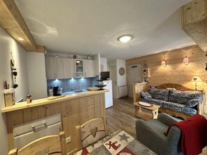 A compact living space with a kitchenette, a sofa, a small table, and a patterned rug. - Ground floor, tv, 35m², Villard de Lans (Villard-de-Lans)