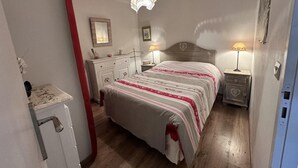 A bedroom with a bed, bedside tables, a dresser, a mirror, and a hanging light fixture. - Ground floor, tv, 35m², Villard de Lans (Villard-de-Lans)