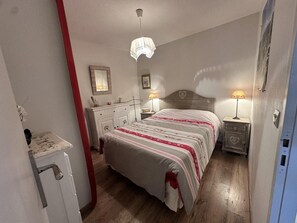 A bedroom with a bed, bedside tables, a dresser, a mirror, and a hanging light fixture. - Ground floor, tv, 35m², Villard de Lans (Villard-de-Lans)