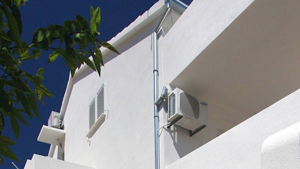 A modern building with a white exterior, a staircase, and two air conditioning units. - Modern Flat With sea View (Orebic)