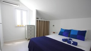 A bedroom with a bed, a wardrobe, a window, and a curtain. - Modern Flat With sea View (Orebic)