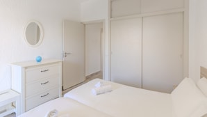 A bedroom with a bed, a dresser, a mirror, and a wardrobe. - #374 Cozy & Bright Stay | City Comfort (Albufeira)