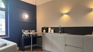 Una cocina moderna con estufa integrada, un lavamanos y una zona de comedor con banco y cojines.