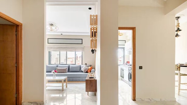 Un'ampia zona giorno con divano, tavolino e vista sulla cucina.
