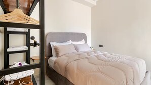 Una camera da letto con un letto, un comodino, una lampada, un armadio e un lampadario.