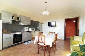 A compact living space with a kitchen, dining area, and a sofa. - Il Casale del Roero - Relaxation among Vineyards, Nature and Tradition (Canale)