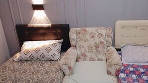 Three beds with different headboards and patterned bedding in a room with vertical wall paneling and wall-mounted lighting. - Room-standard Twin Bedroom (Istanbul)