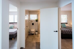 A bedroom with a bed, a bedside table, and a window. - Aqua Vista, Oceanview Villa with infinity pool Coral Estate close to the beach! (Sint Willibrordus)