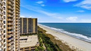 Ein Hochhaus mit Balkonen mit Blick auf einen Strand.