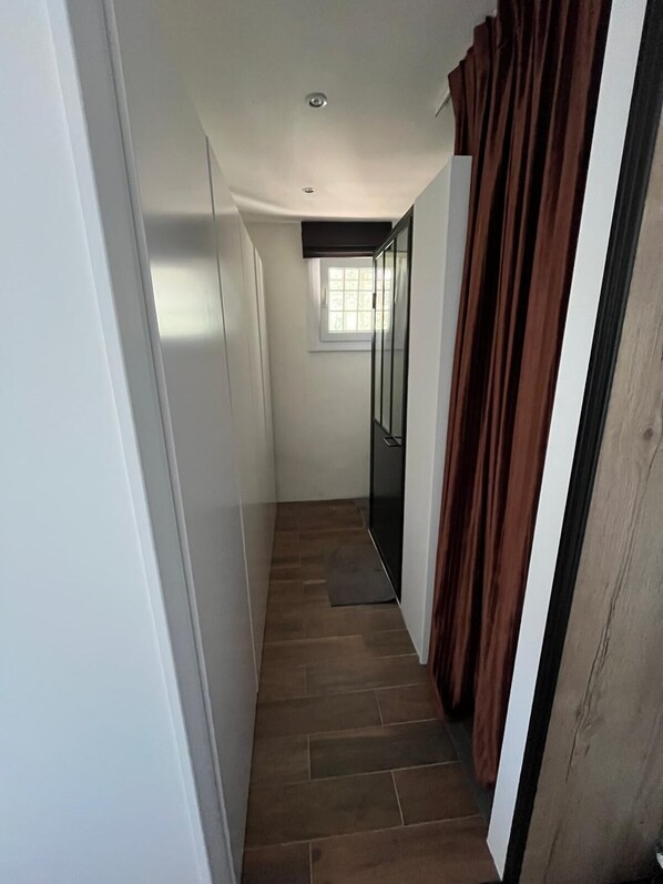 A narrow hallway with a window, a door, and a curtain. - Charming studio with a view of the sea in the heart of La Croix Valmer (La Croix-Valmer)