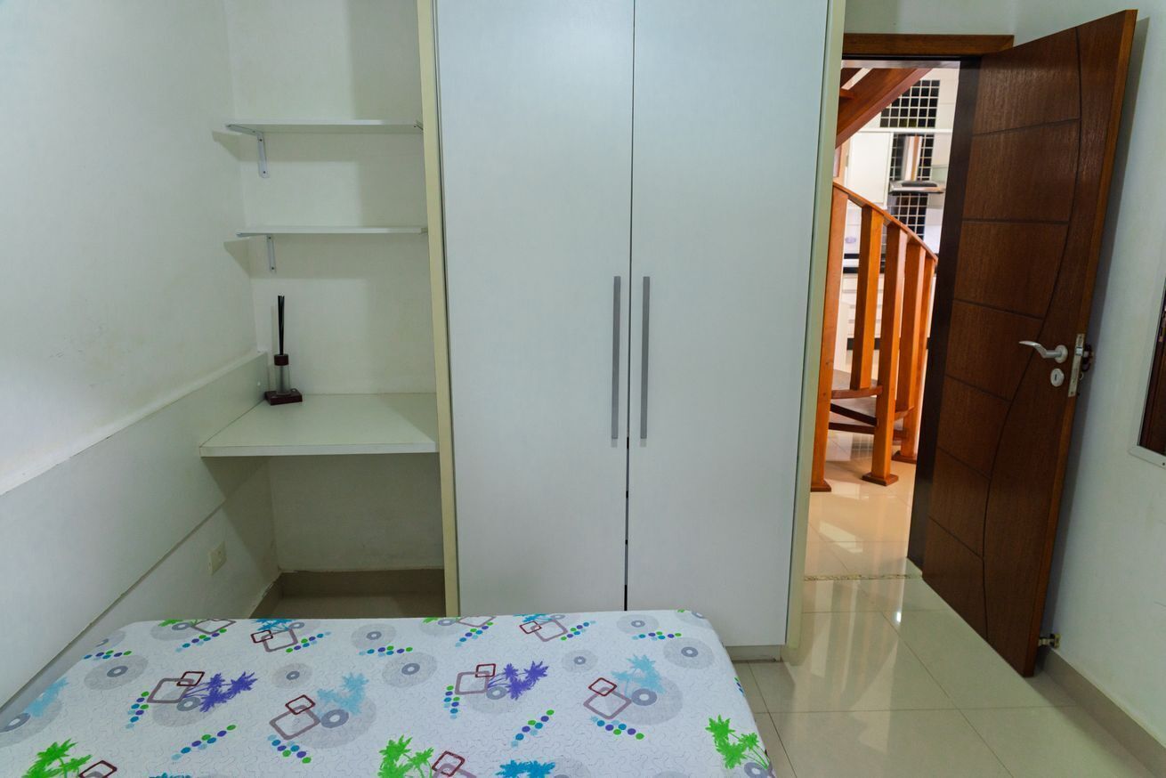 A bedroom with a bed, wardrobe, and a door leading to a staircase.