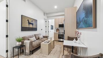Un salon moderne comprenant un canapé, une table basse et un coin repas avec une table et des chaises.
