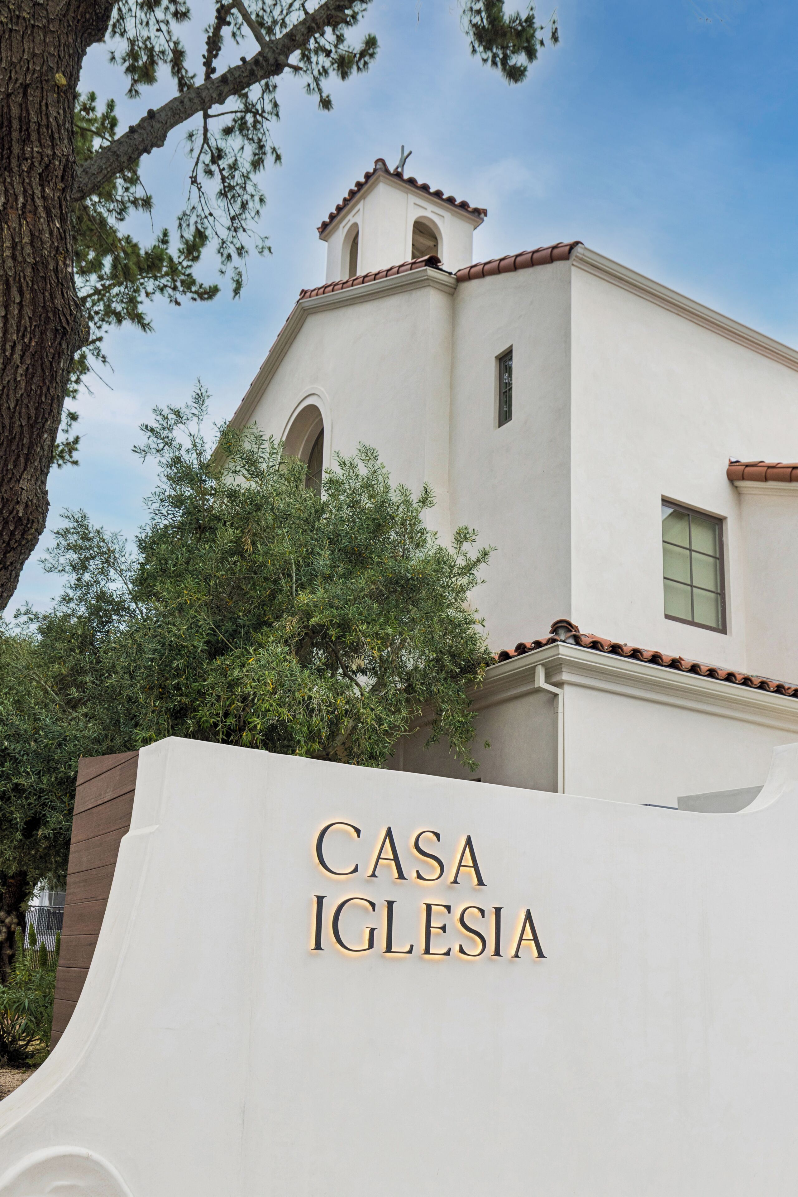 A building with a white facade and a red-tiled roof, labeled 'CASA IGLESIA.'