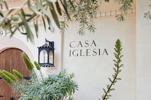 Un mur sur lequel on peut lire l’inscription « CASA IGLESIA » et une porte en bois.