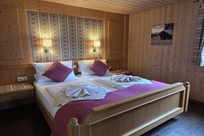 Habitació amb panells de fusta, un llit, dues làmpades de nit i una obra d'art penjada a la paret.