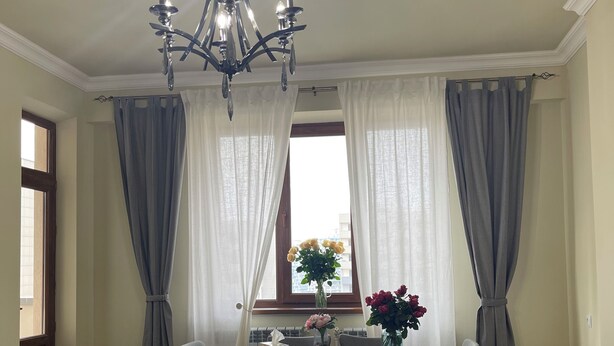 A dining room with a chandelier, a dining table with chairs, and a window with curtains. - Wonderful 2-bedroom apartment with AC in vibrant Yerevan 🫶✨💖 (Yerevan)