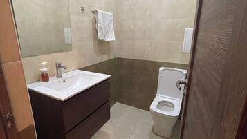 Un bagno con lavandino, specchio e WC.