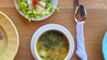 Uma mesa com uma tigela de sopa e uma salada.