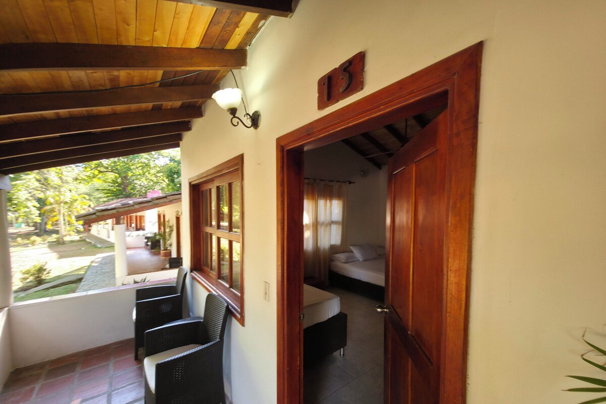 Um quarto com uma cama, uma janela e uma porta que dá para outro quarto.