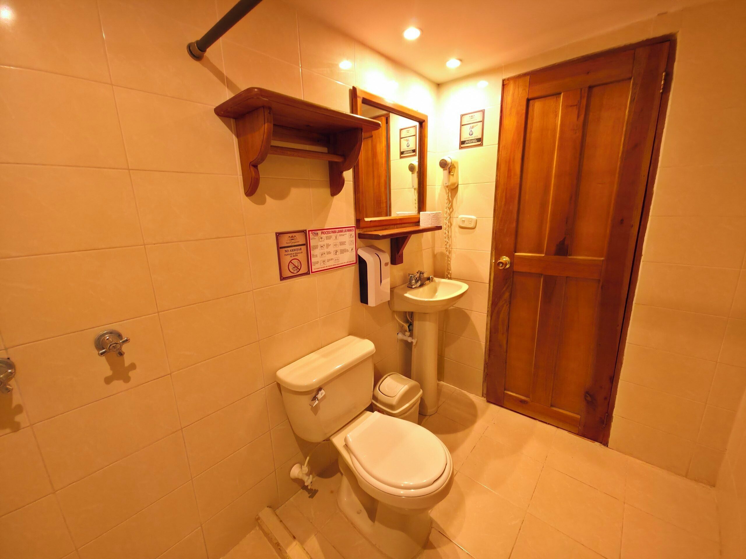 Ein Badezimmer mit Toilette, Waschbecken und Holztür.