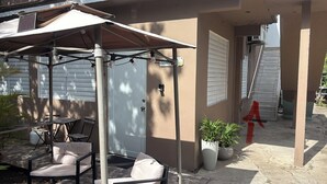 A covered patio area with a table and chairs, a potted plant, and a door. - TROPICAL ESCAPE IN VIEQUES NEAR THE BEACHES (WE HAVE WATER) (Vieques)