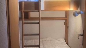 A bunk bed room with a ladder, a headboard, and a wall-mounted light fixture. - 200m from ski lifts, 1st floor, balcony, parking, tv, ski locker, 25m², Combloux (Combloux)