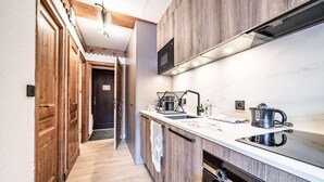 Cozinha moderna com armários de madeira, forno embutido e pia.