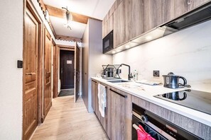 Eine moderne Küche mit Holzausstattung, einem eingebauten Ofen und einem Spülbecken.